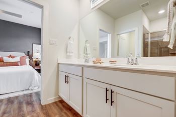 a bathroom with white cabinets and a large mirror